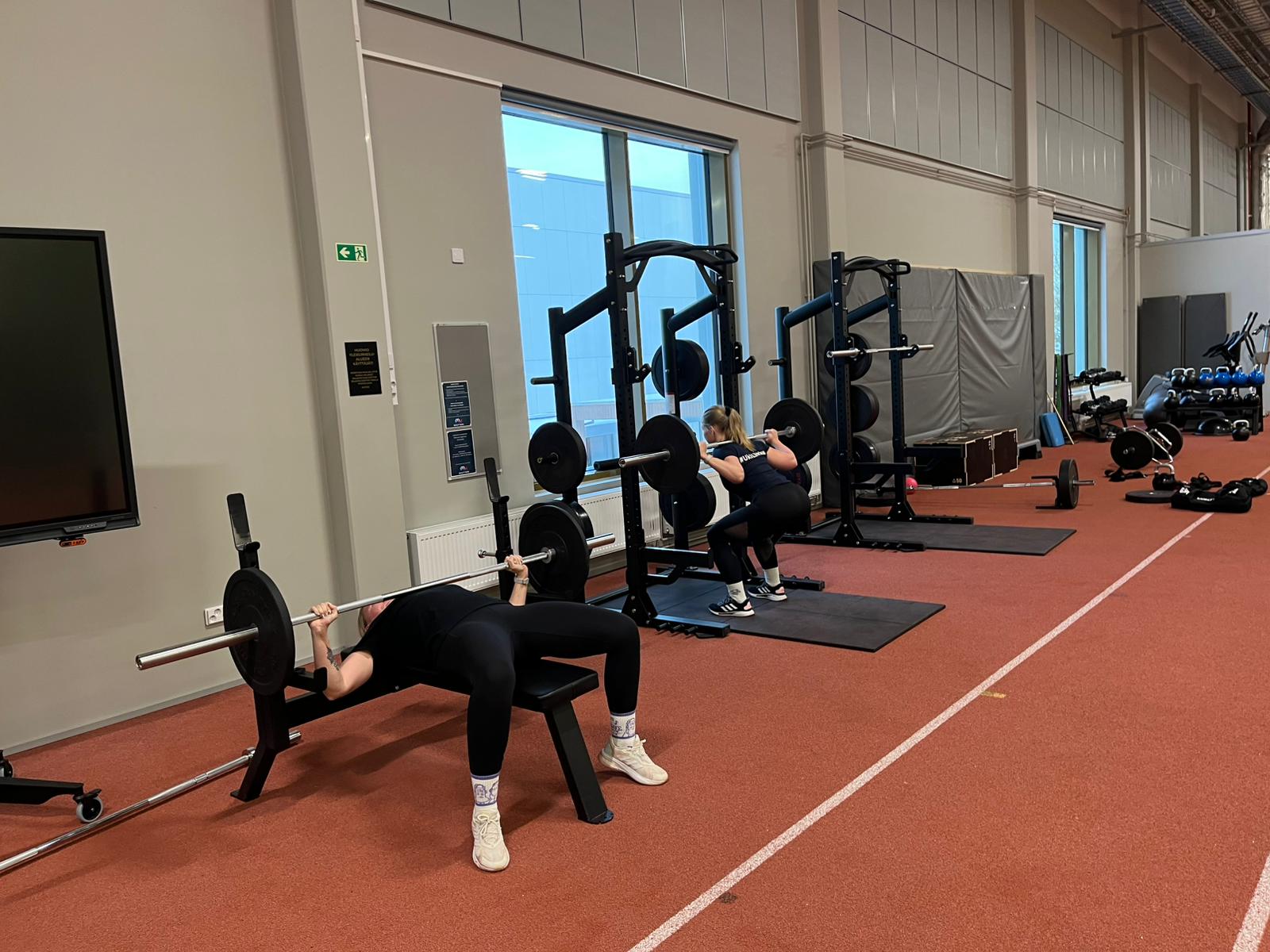 naisia treenaamassa yleisurheilutilassa